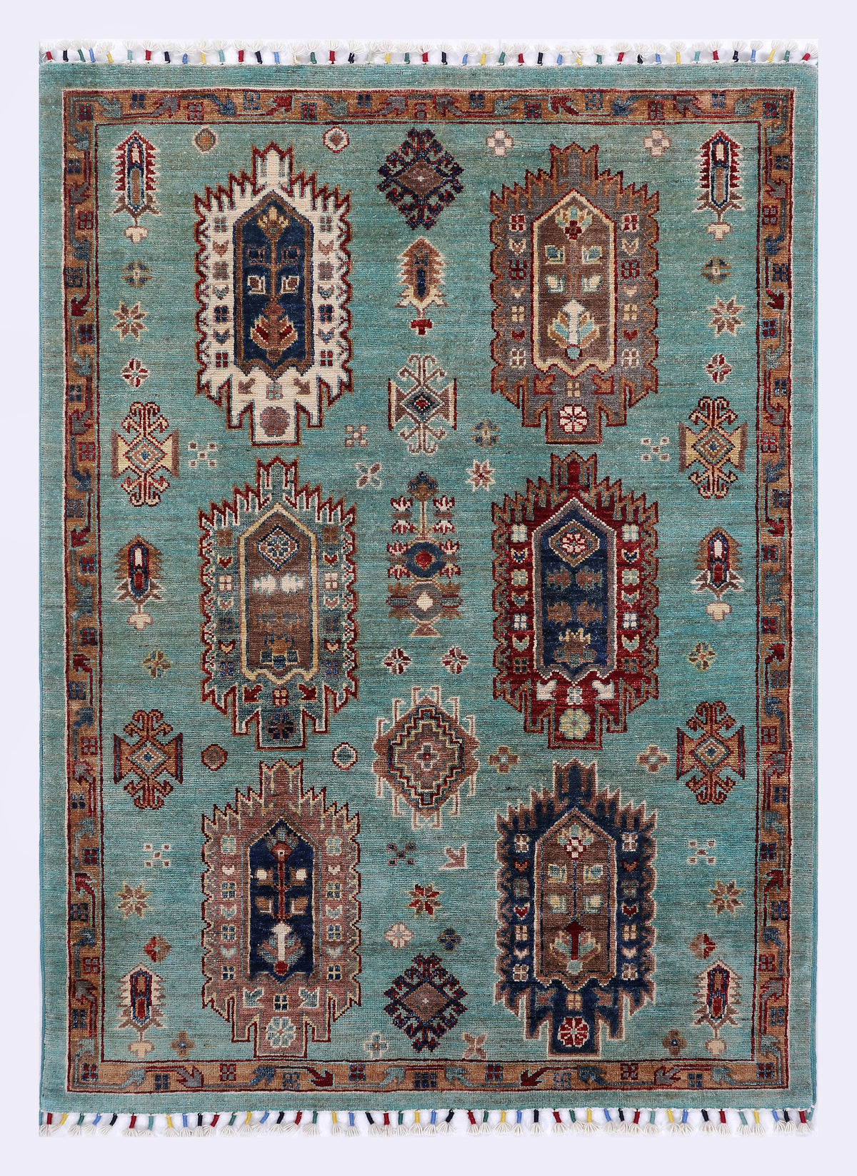 Turquoise patterned area rug with central medallions and geometric borders, fringed edges