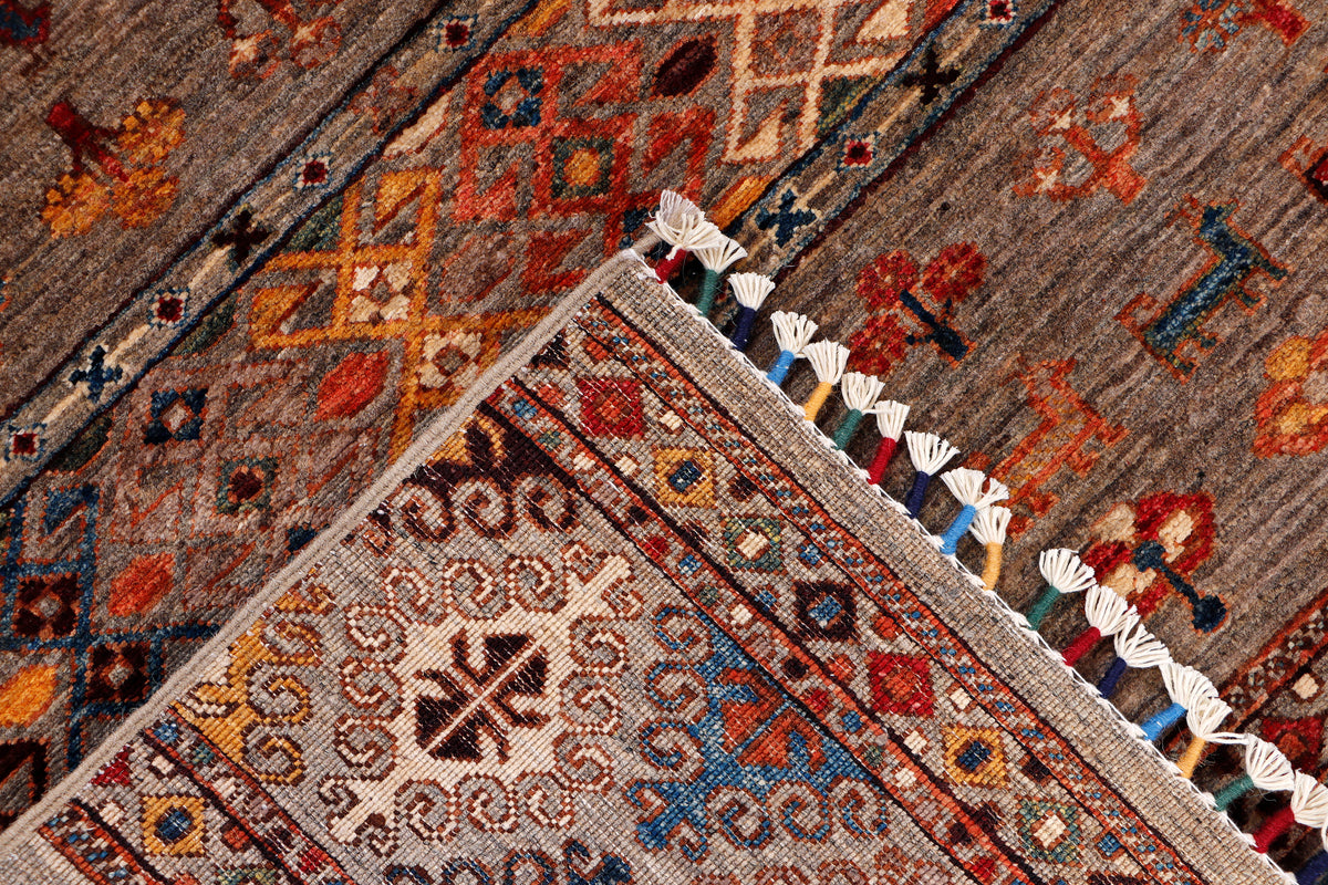 Rug corner with detailed geometric motifs and short white fringes along the edge.