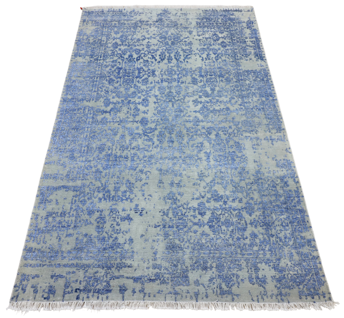 Rectangular blue mist rug with distressed allover pattern and short fringed border, full view.