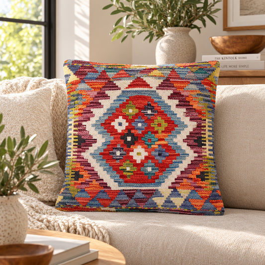 Kilim cushion front with red medallion motif and multicolor geometric border, angled view
