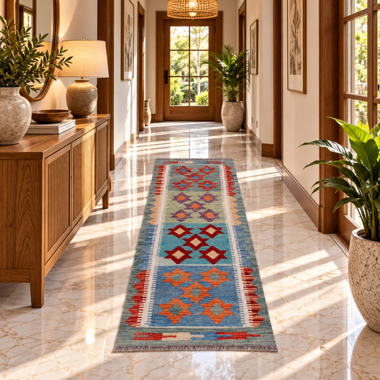 Kilim rug runner with blue field and orange and red diamond motifs on the floor