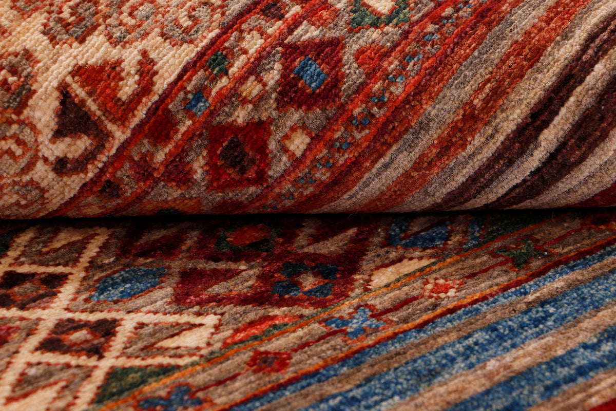 Red geometric patterned rug with blue border