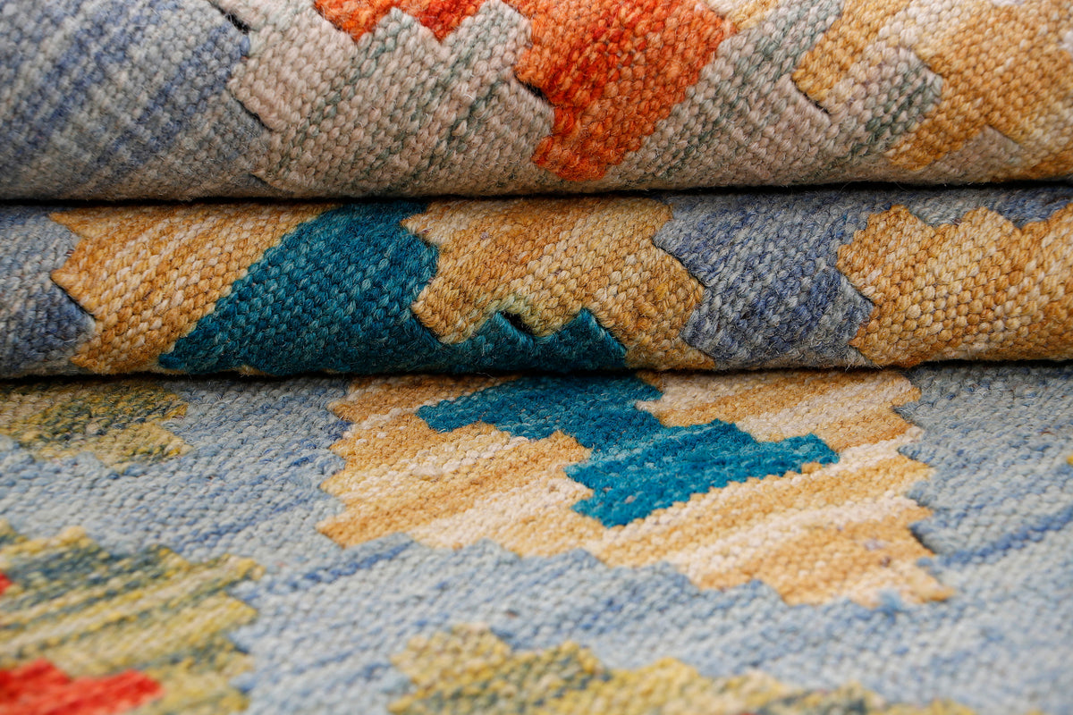 Kilim rug close-up of textured weave with blue, orange, and teal pattern sections