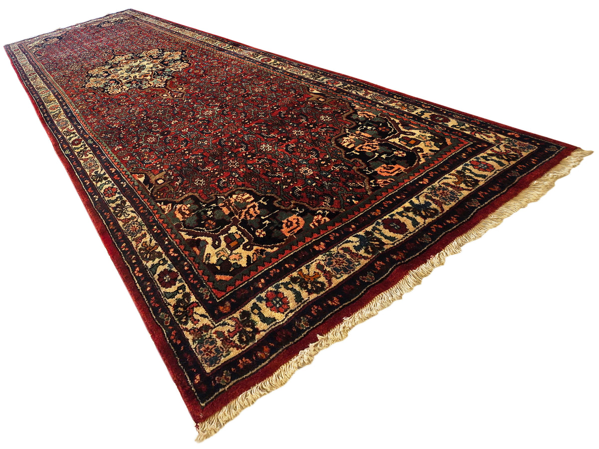 Bidjar rug corner view, dark red pattern with cream diamond motifs and short fringes