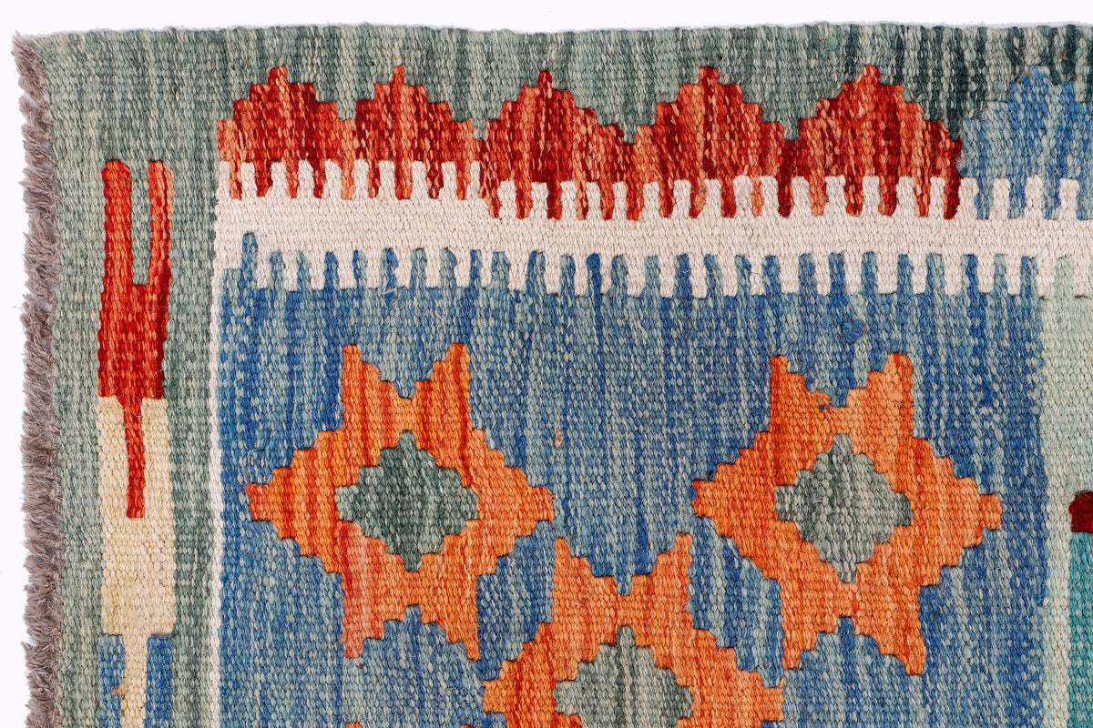 Kilim rug border with repeating diamonds in orange, red, and blue plus short fringe
