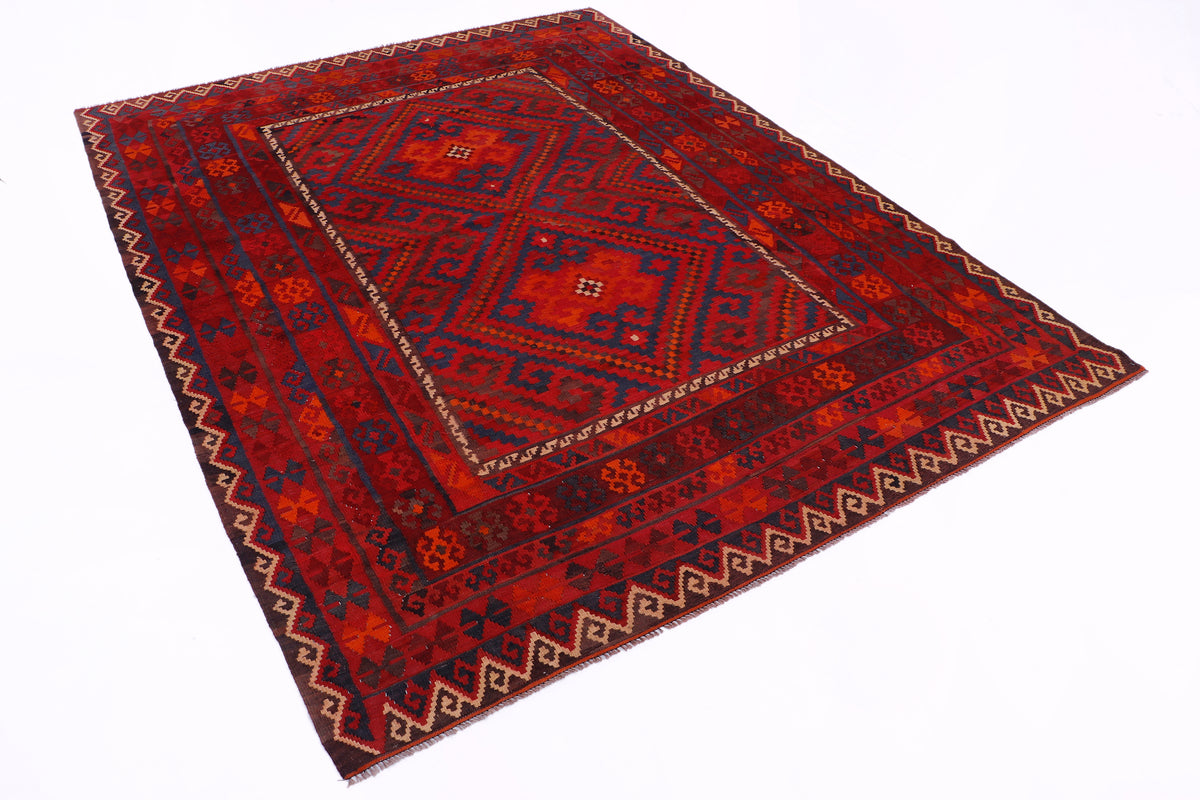 Red kilim rug with central diamond medallion and dark blue geometric border.