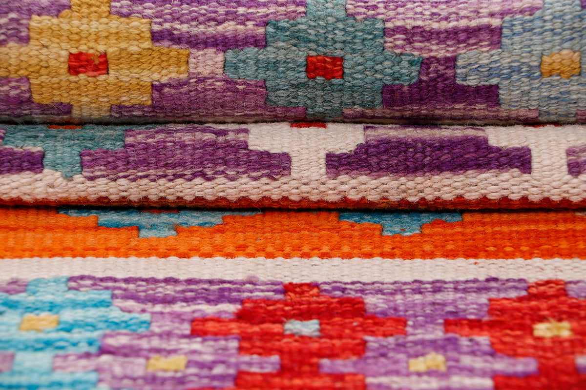 Kilim rug woven texture close-up with purple, orange, red, and blue rows
