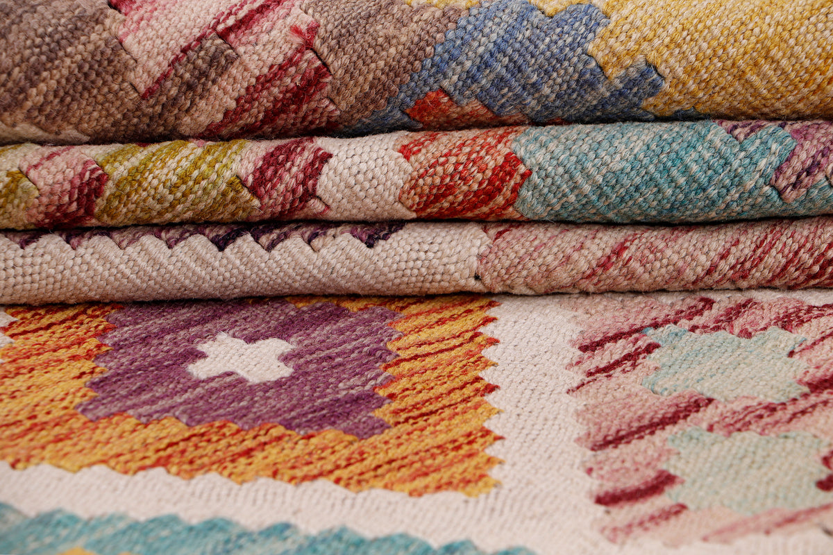 Beige kilim rug woven texture close-up with colorful motif and visible stitching