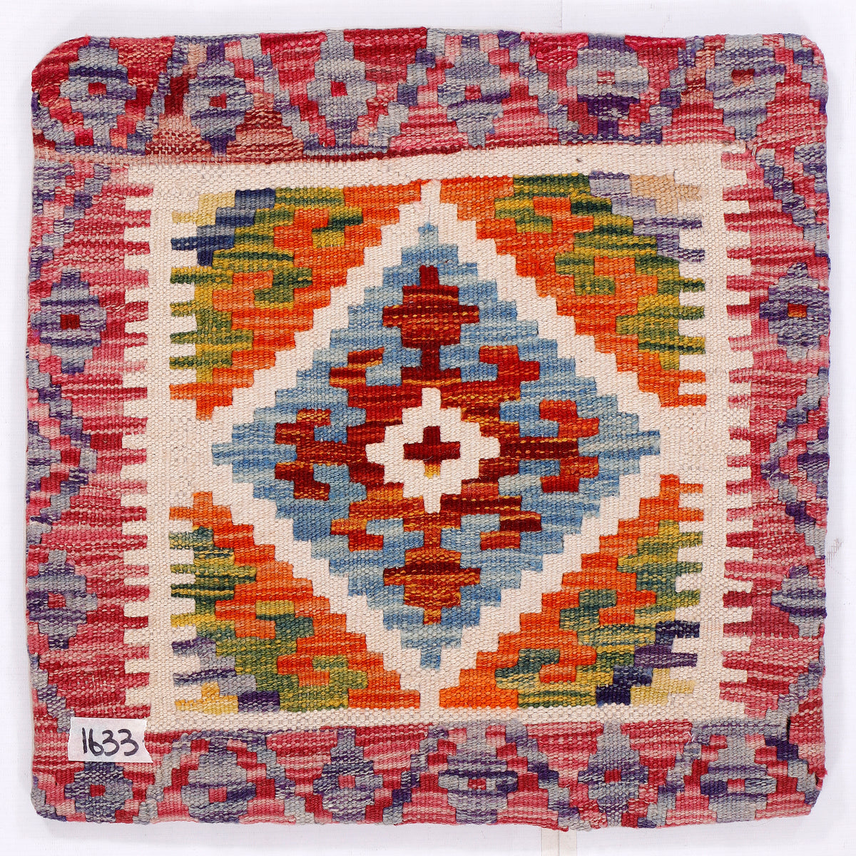 Front of diamond kilim cushion cover with red border and multicolor geometric motif