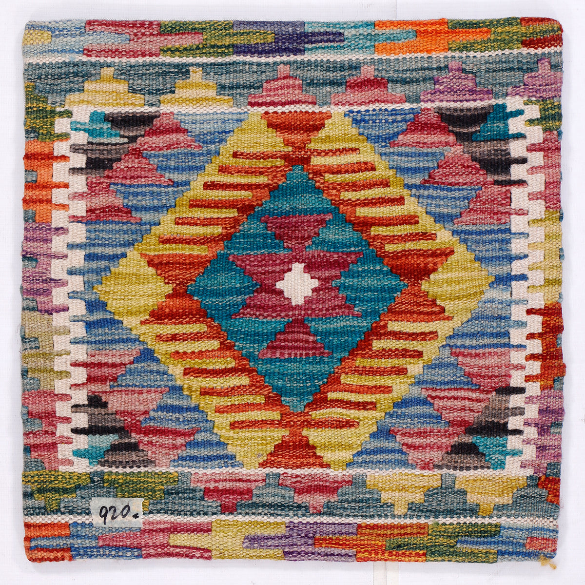 Kilim cushion with bold geometric pattern in turquoise, red, yellow, and blue