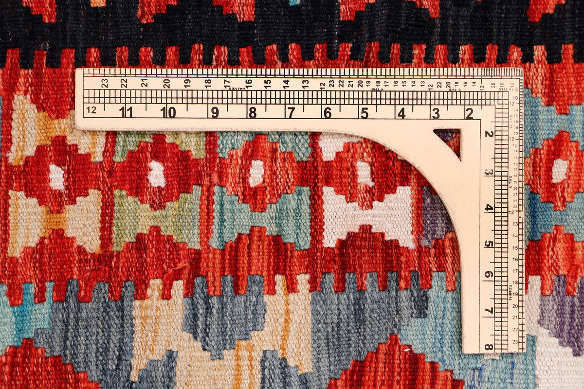 Kilim rug close-up with arched geometric motif in red, blue, cream, and black