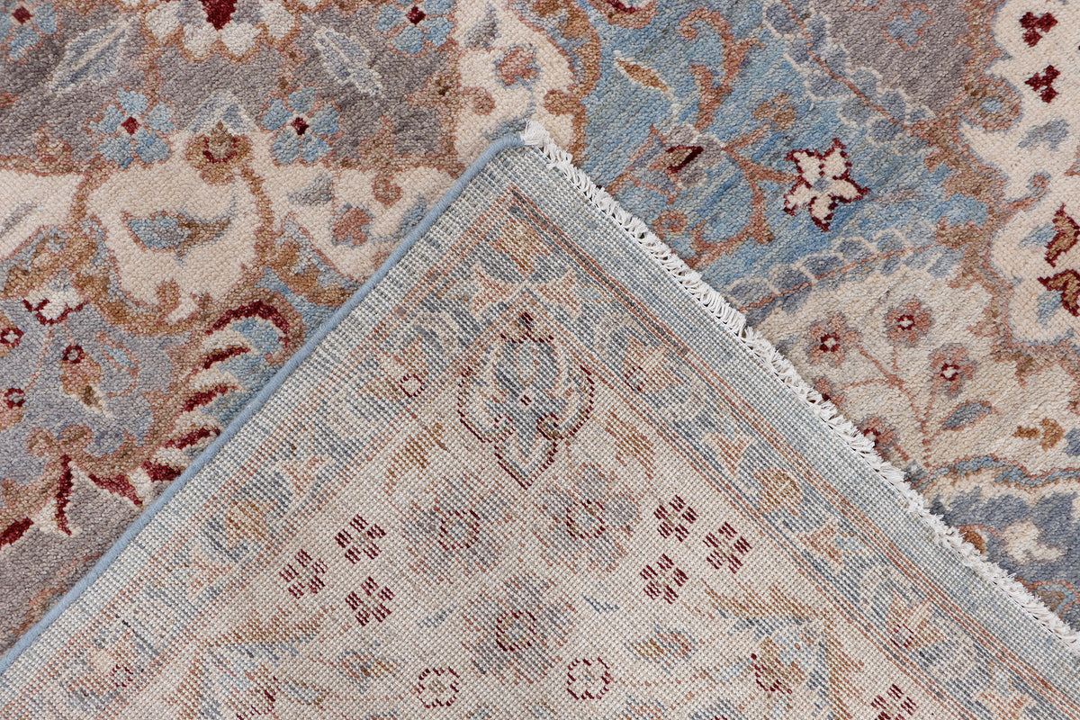 Rug corner close-up with blue and beige medallion details and textured edge