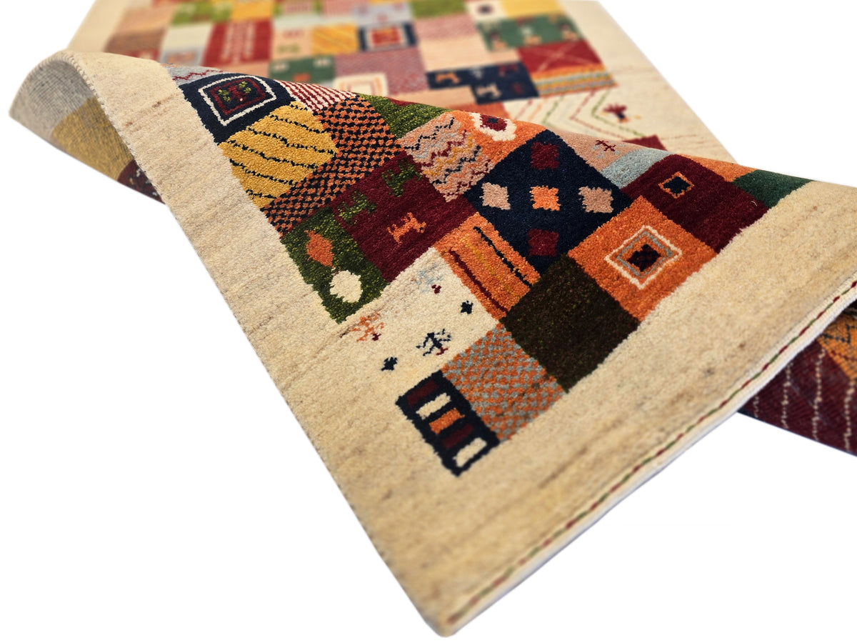 Corner view of Loribaft rug with multicolor geometric patchwork on beige pile.