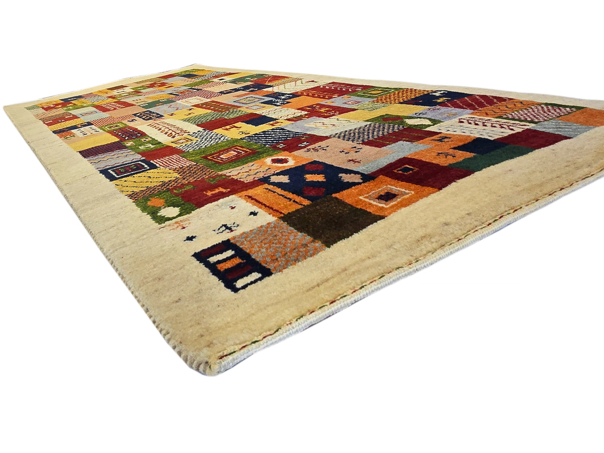 Loribaft patchwork rug with multicolor geometric designs on a beige field.