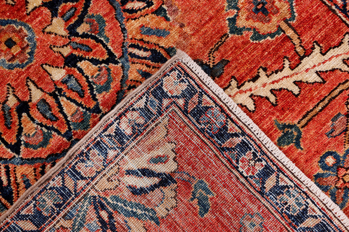 Red patterned rug corner with geometric border detail and blue trim