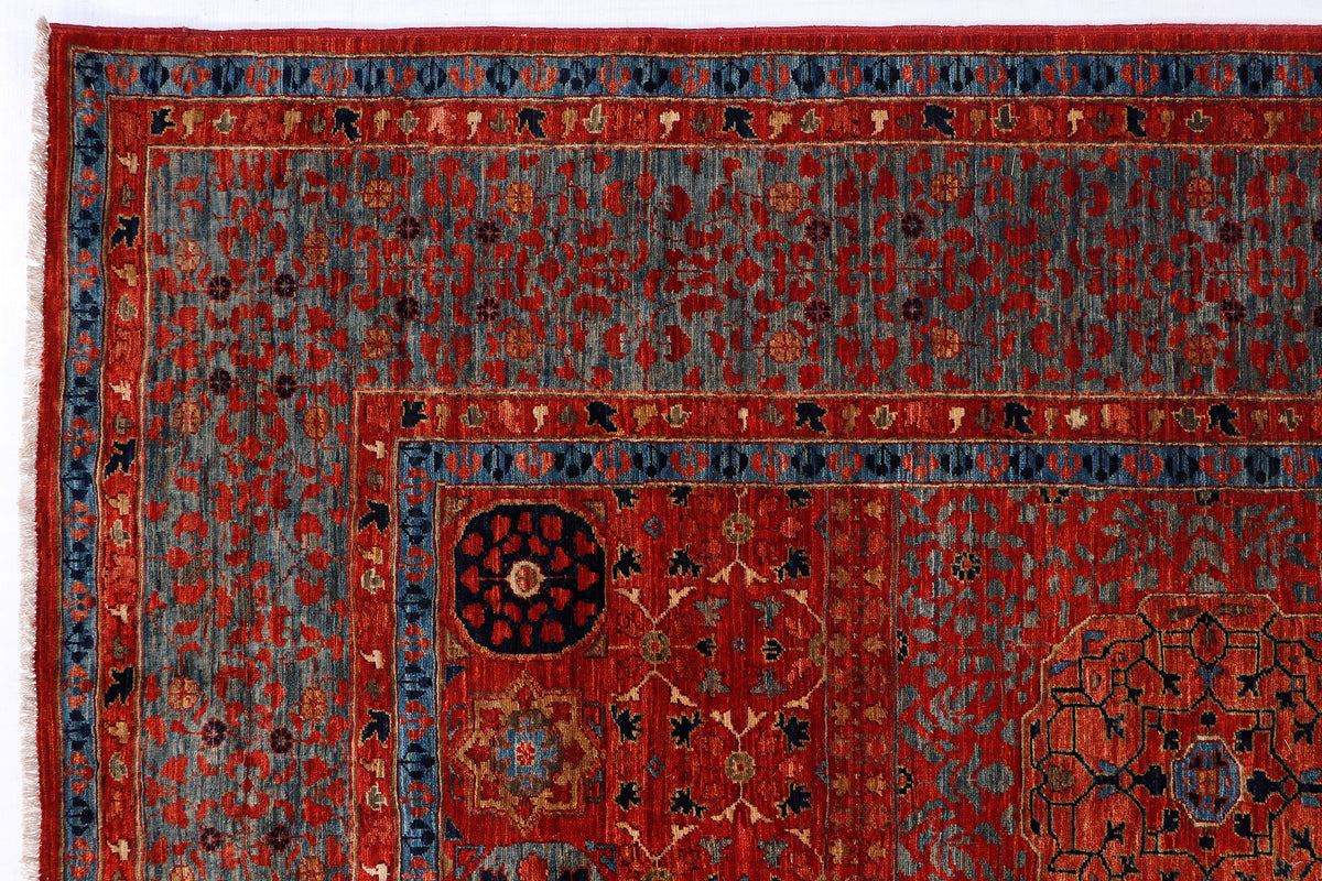 Close-up of traditional patterned wool rug in red with blue border and medallion details