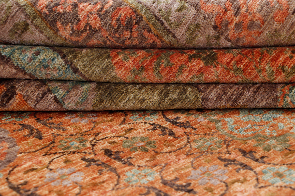 Folded rug showing flatweave texture; rust, teal, olive, and beige bands.