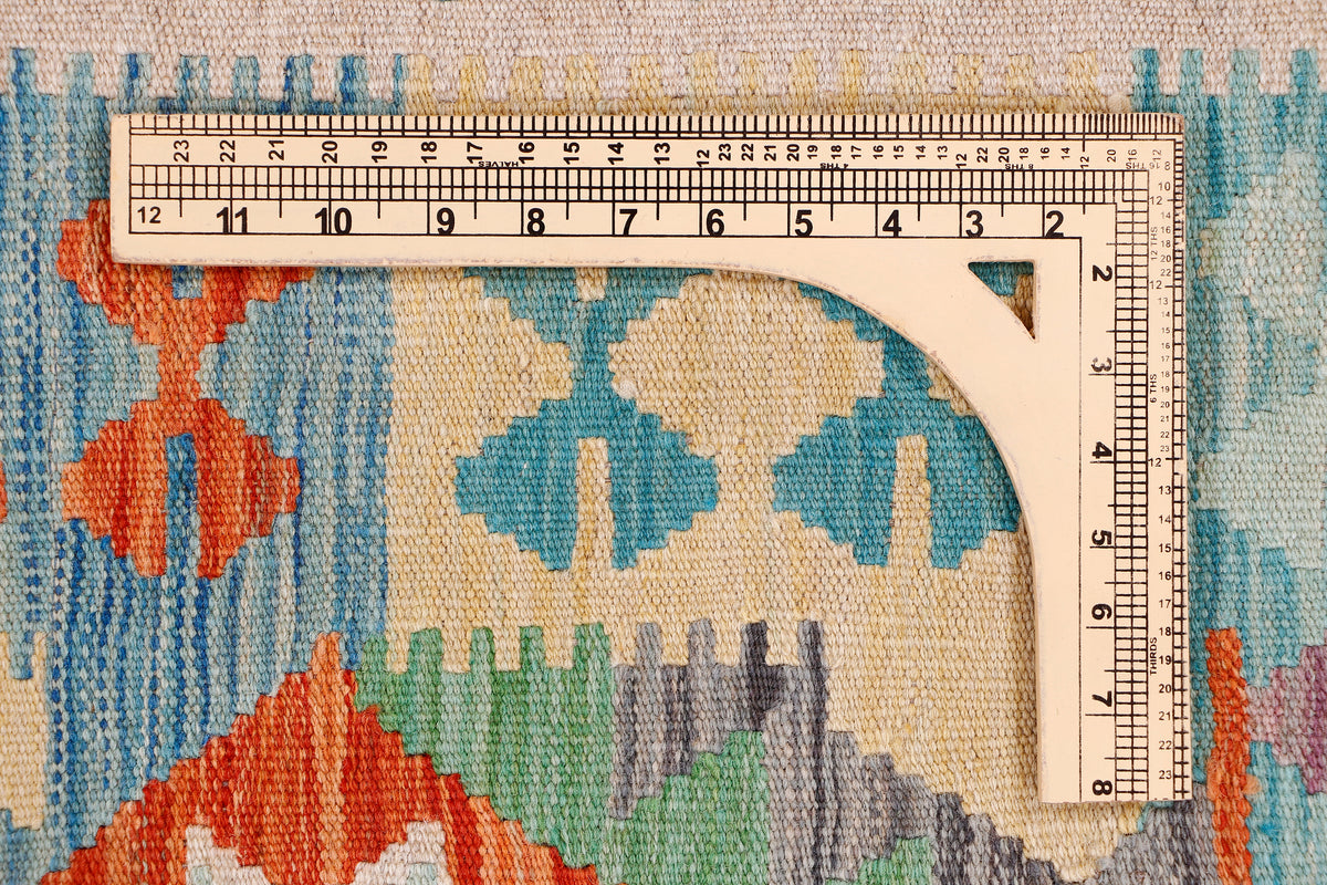 Flatweave area rug corner with blue, orange, green, and cream geometric pattern
