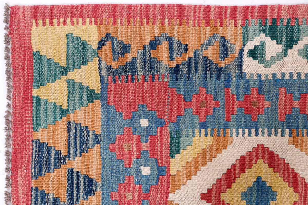 Close-up of multicolor kilim rug weave with red border and blue geometric motifs