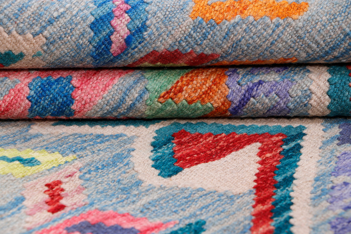 Blue kilim rug with diamond motifs and red, orange, purple accents; short woven texture