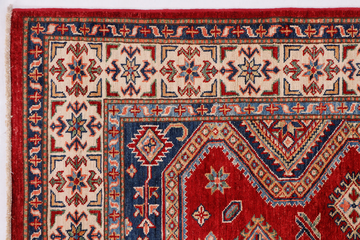 Red and blue rug with repeating geometric motifs and central medallion