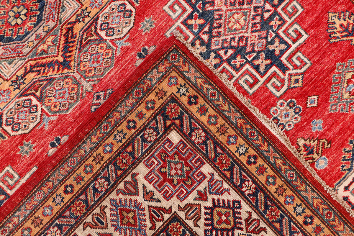 Red traditional rug with geometric medallion pattern and border details.