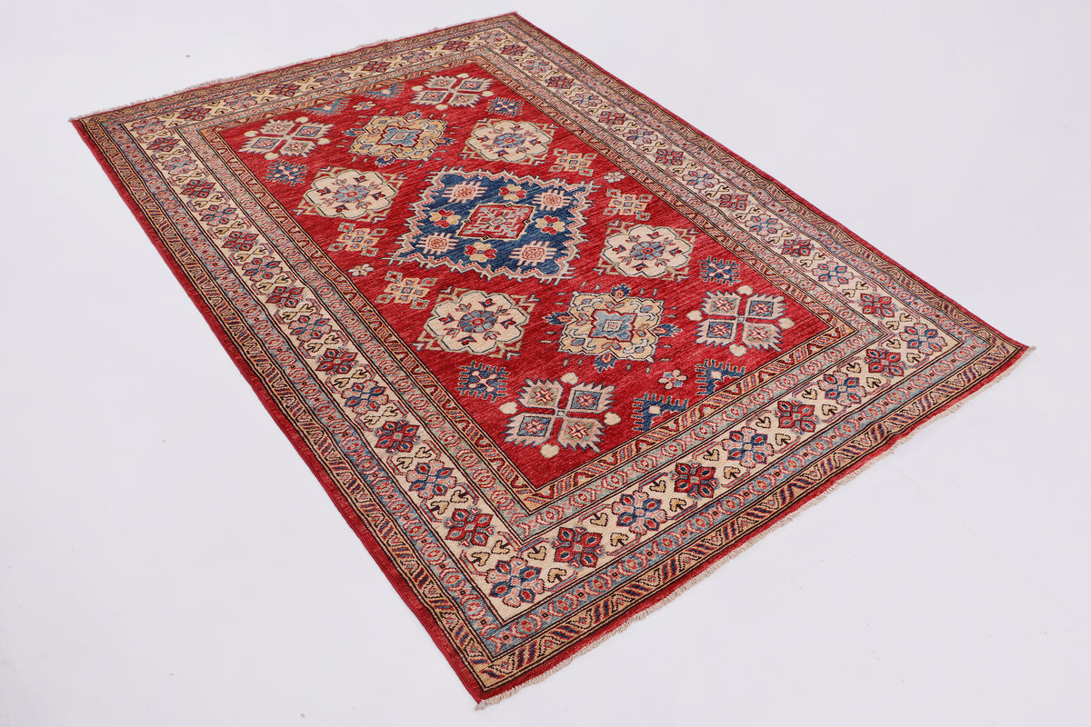 Red patterned rug with central medallion and decorative border, laid flat