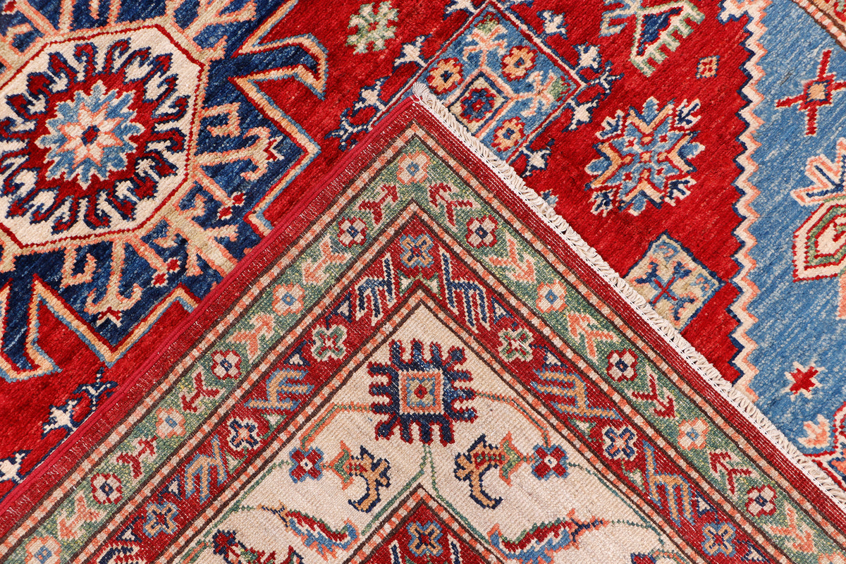 Kazak rug corner with red, blue, and cream geometric motif and triangular design