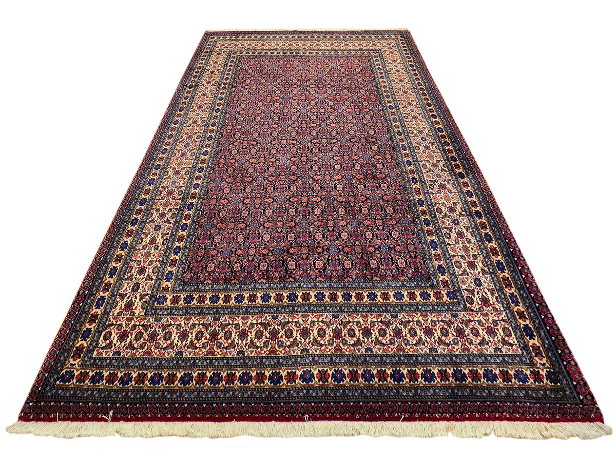 Maroon area rug with navy and gold border stripes and small repeating floral motifs.