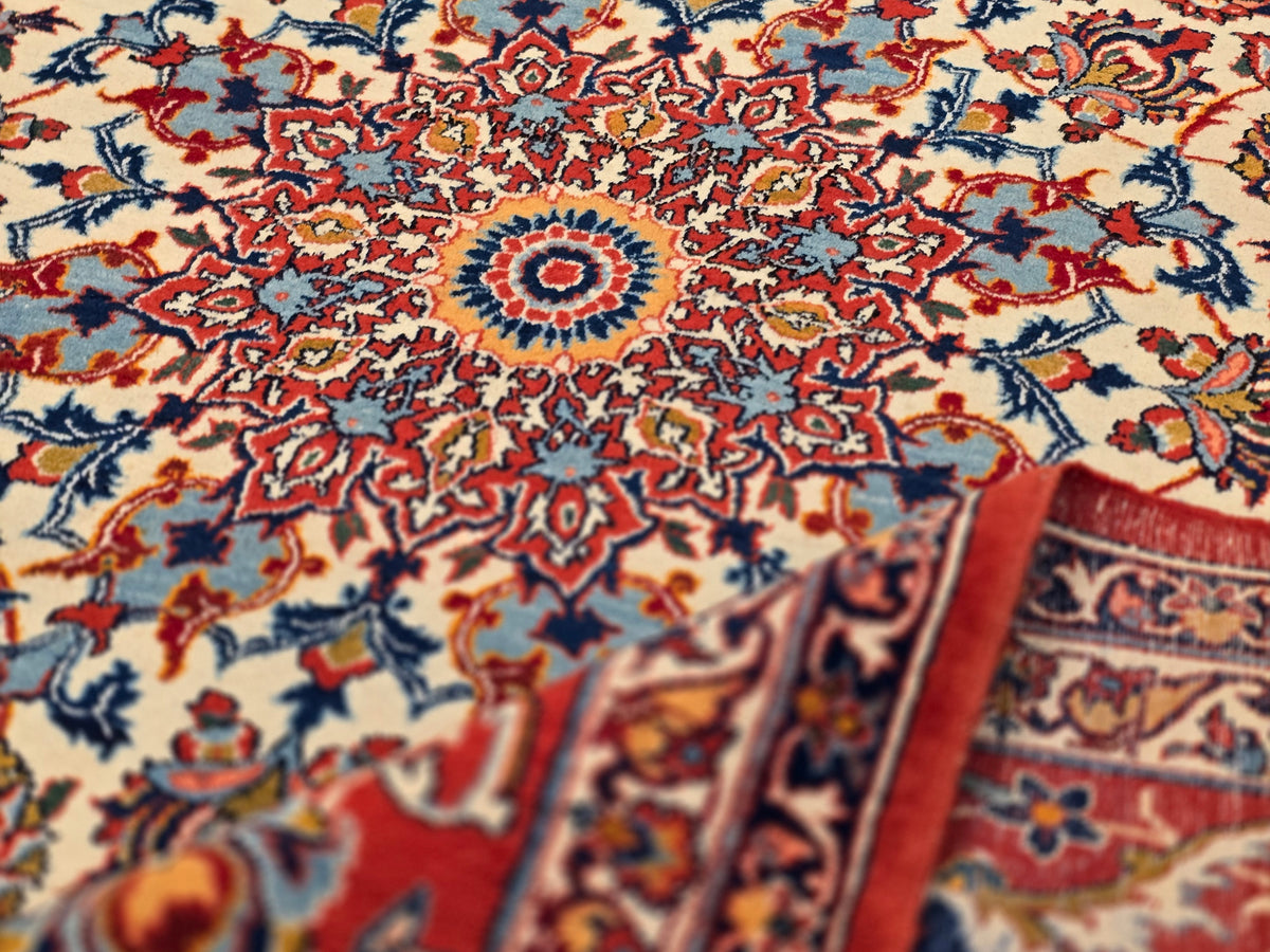 Colorful red, blue, and cream floral patterned rug corner with fringed edge
