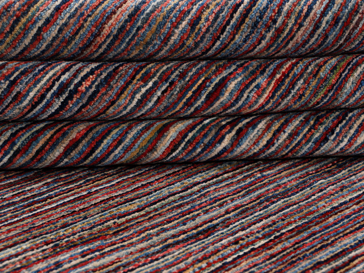 Multicolor striped rug close-up with navy, orange, and blue line pattern.