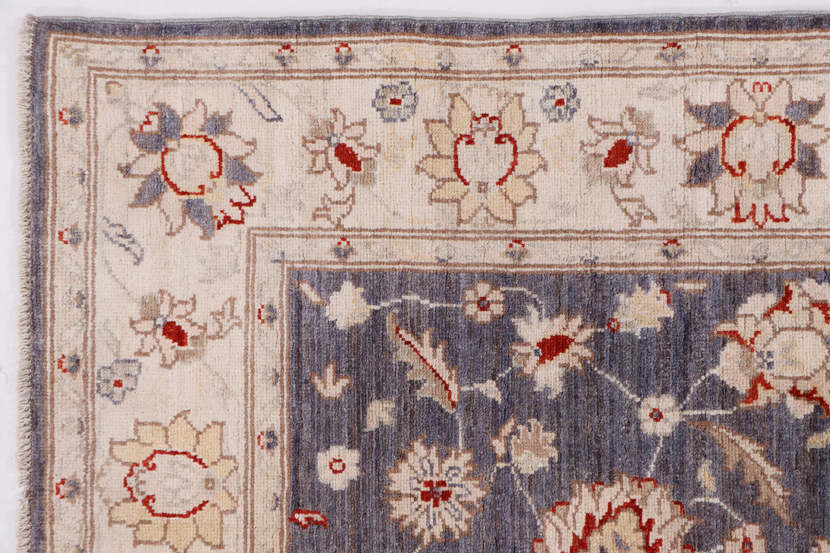 Close-up of blue rug with ivory background, red and navy floral motifs