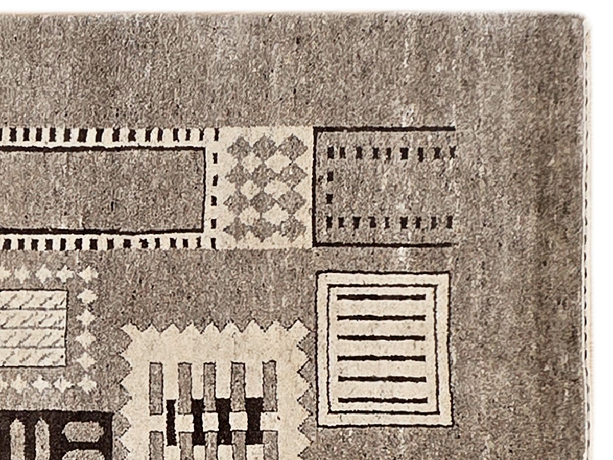 Close-up of geometric patchwork rug texture with dark and light rectangle motifs
