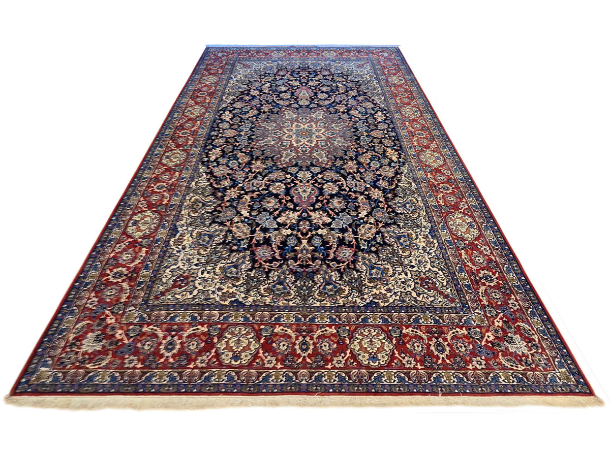 Rectangular Persian-style rug with navy-blue center medallion and red patterned frame