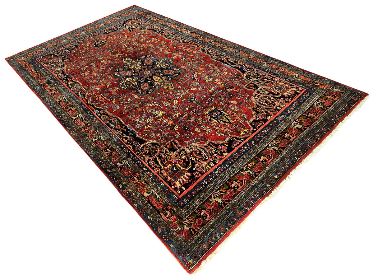 Red and navy patterned rug with symmetrical corner ornaments and detailed border
