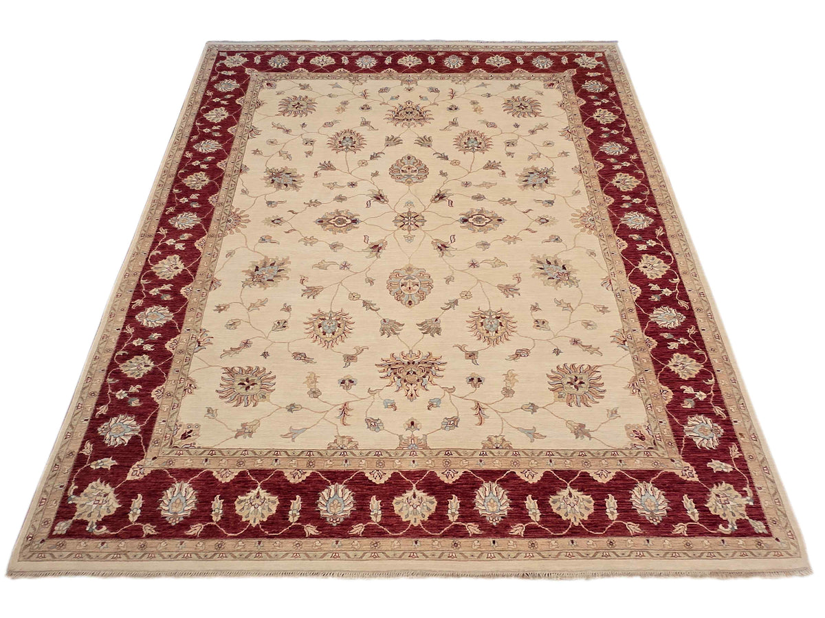 Area rug with cream center, burgundy border with repeating corner motifs, fringed edges
