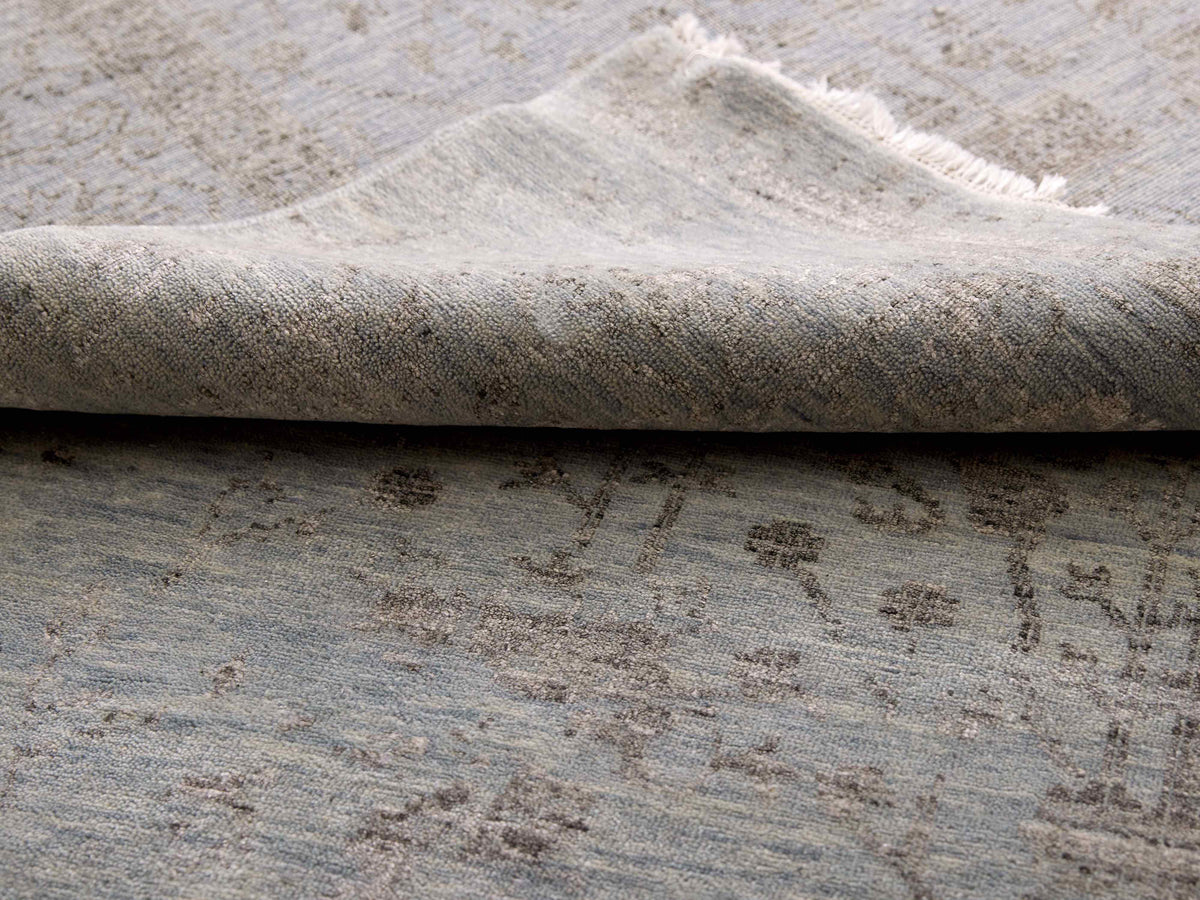 Light gray distressed area rug with subtle abstract pattern and short pile texture