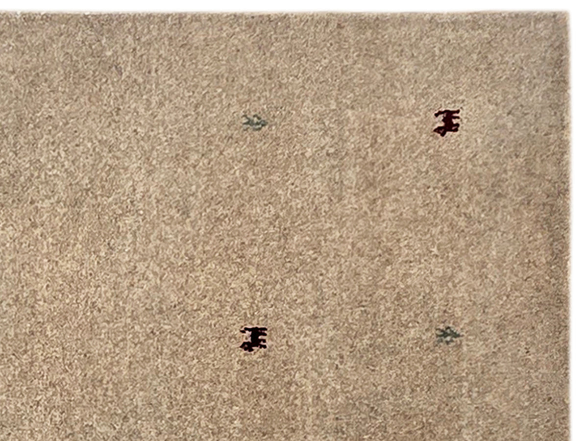 Beige handloom rug close-up with scattered multicolor motifs, dense flatwoven pile