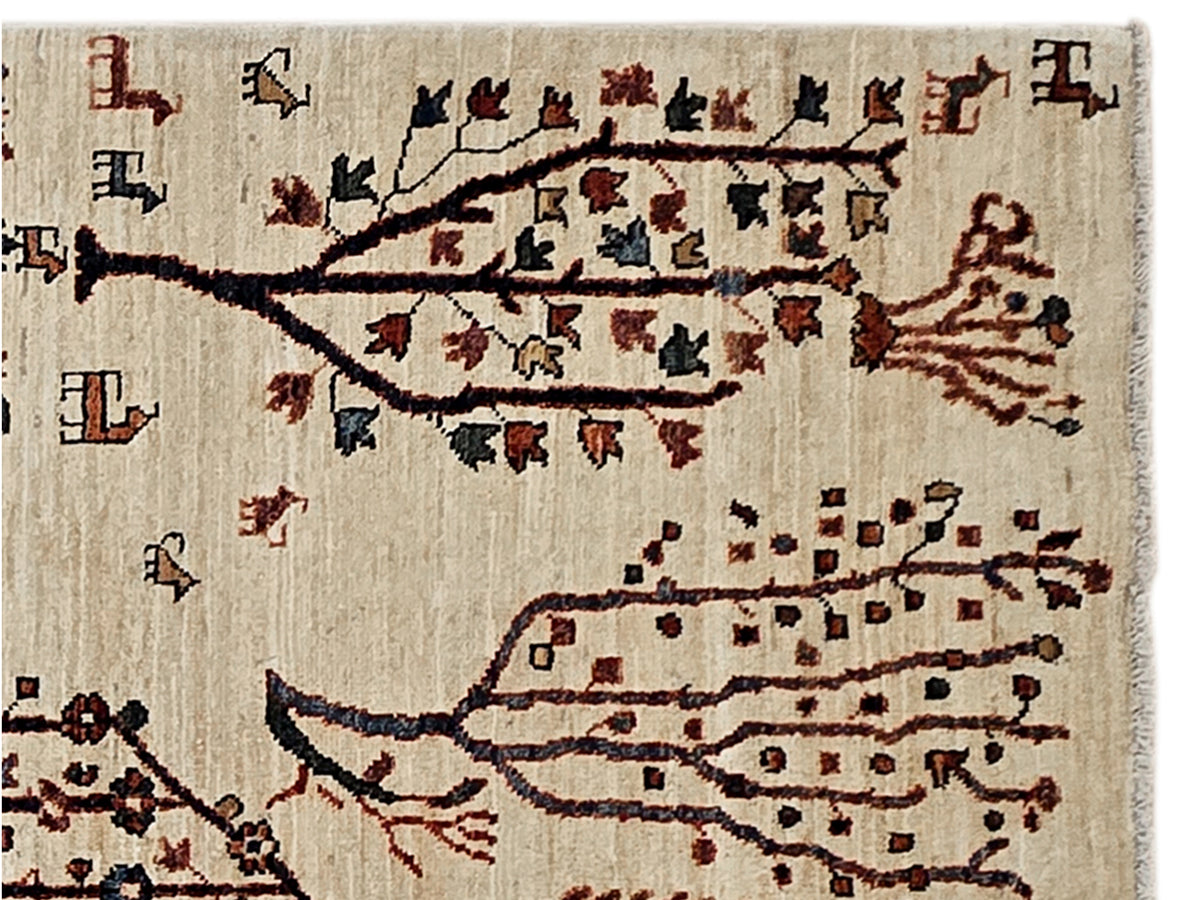 Cream rug with tree branches and medallion patterns in dark and rust red tones