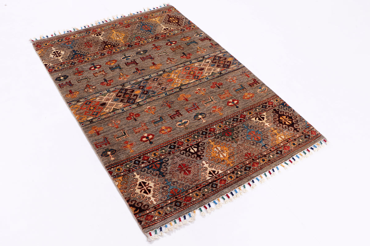 Rectangular grey rug with multicolor medallions, geometric accents, and short side fringes.
