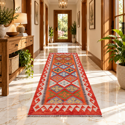 Orange kilim runner rug with multicolor geometric center in a hallway setting