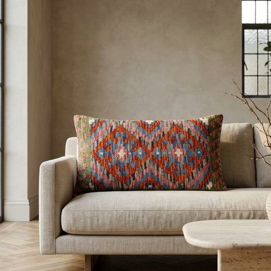 Blue kilim medallion cushion with a woven geometric pattern in blue, red, cream, and green