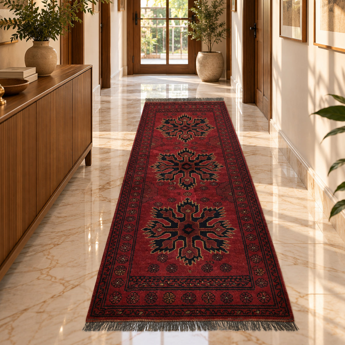 Red Afghan runner rug with central starburst design and dark border, fringed ends.