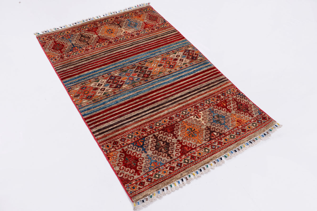 Red and blue patterned area rug with fringe edges