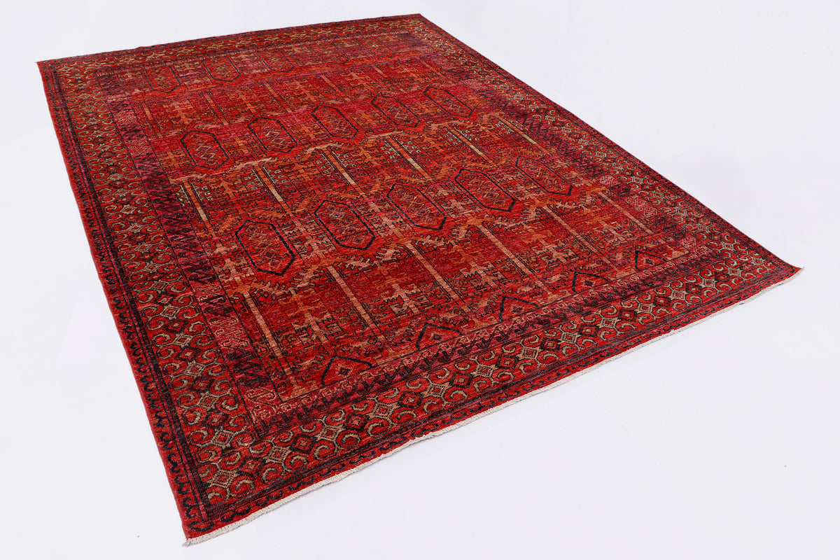 Red patterned rug, full view angled showing wide decorative border