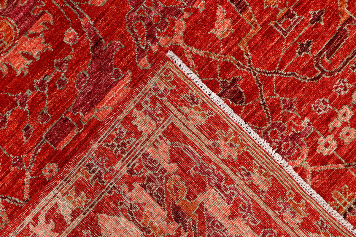 Red vintage rug corner with detailed geometric pattern and off-white border strip.