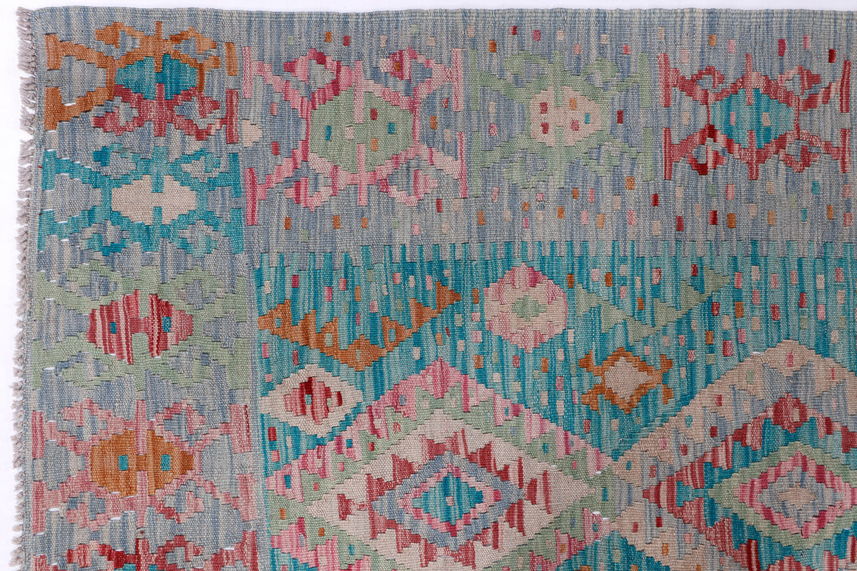 Sky blue kilim rug with pink, orange, and green geometric pattern