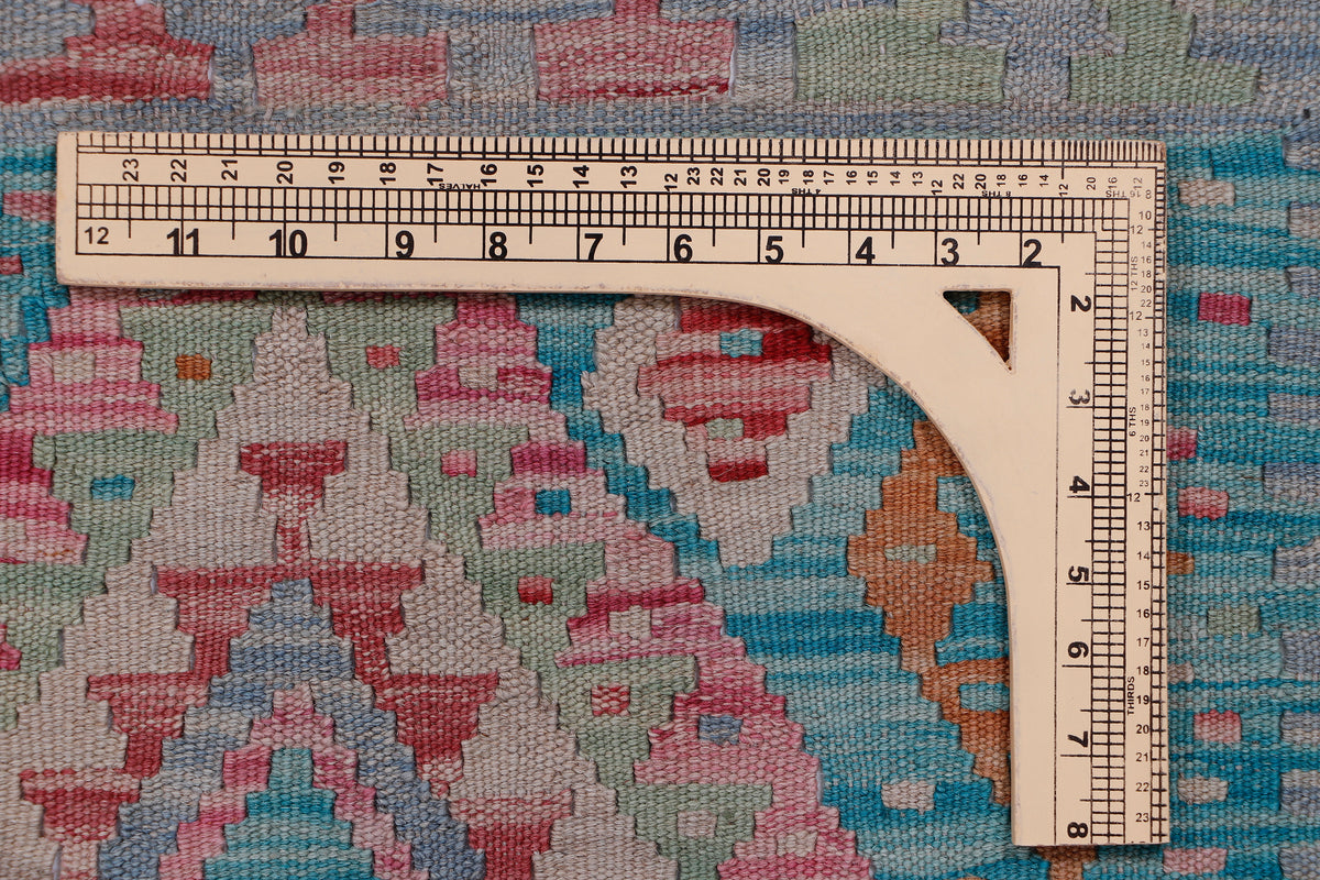 Tape measure on blue kilim rug surface with multicolor geometric pattern
