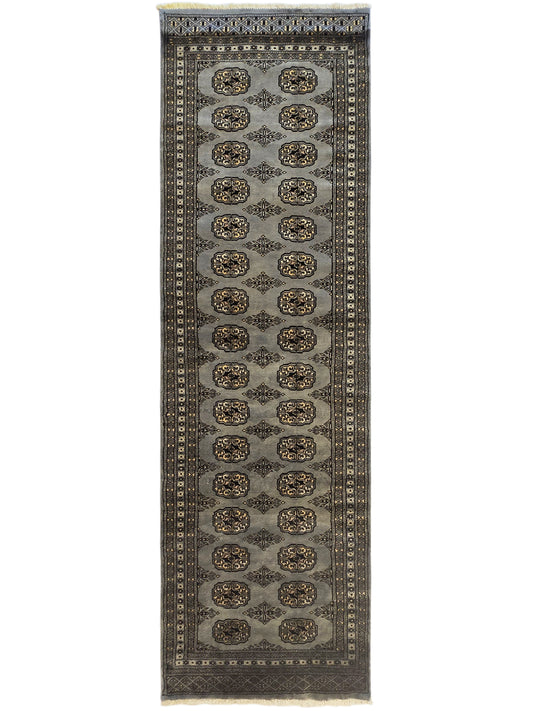 Tall rectangular rug with repeating medallions in rows, dark border, and fringe detailing