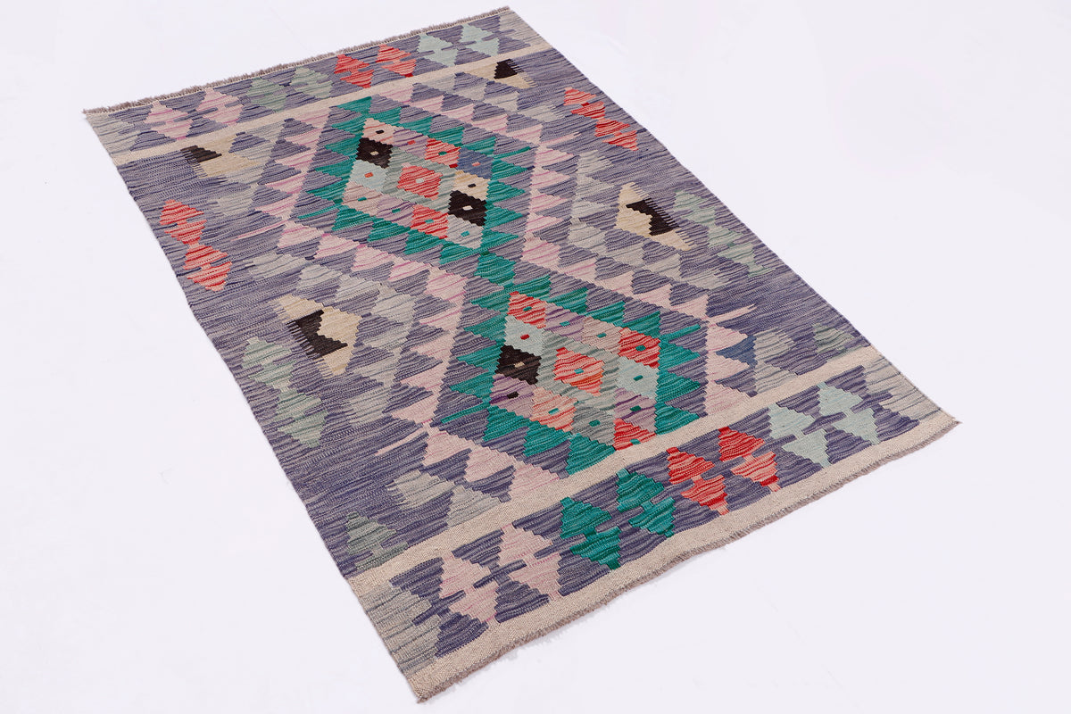 Kilim rug laid flat with repeating diamond motifs in grey, green, teal, and coral